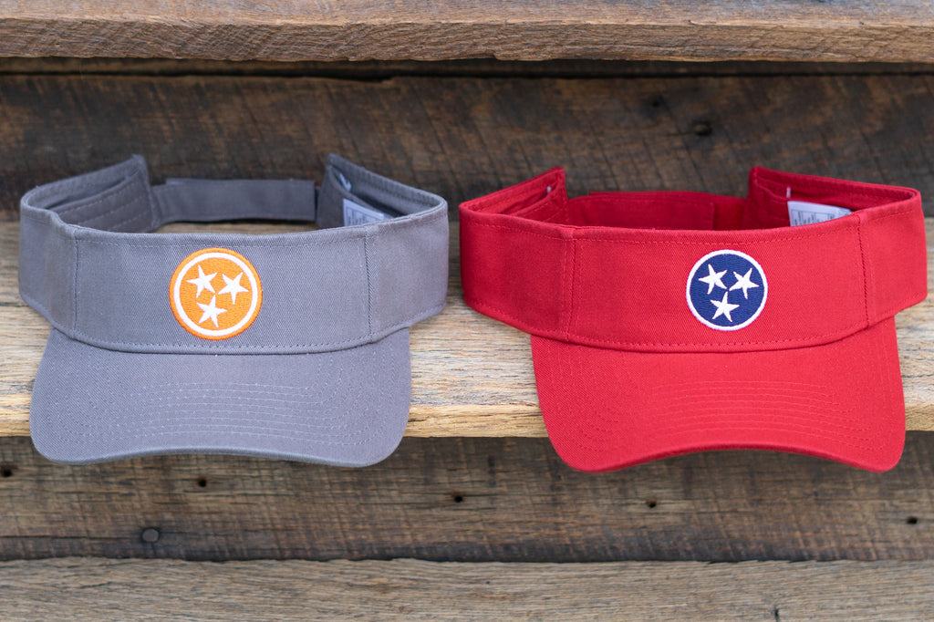 Volunteer Traditions Grey with Orange and Red with Navy Tennessee Tristar Visor on wood.