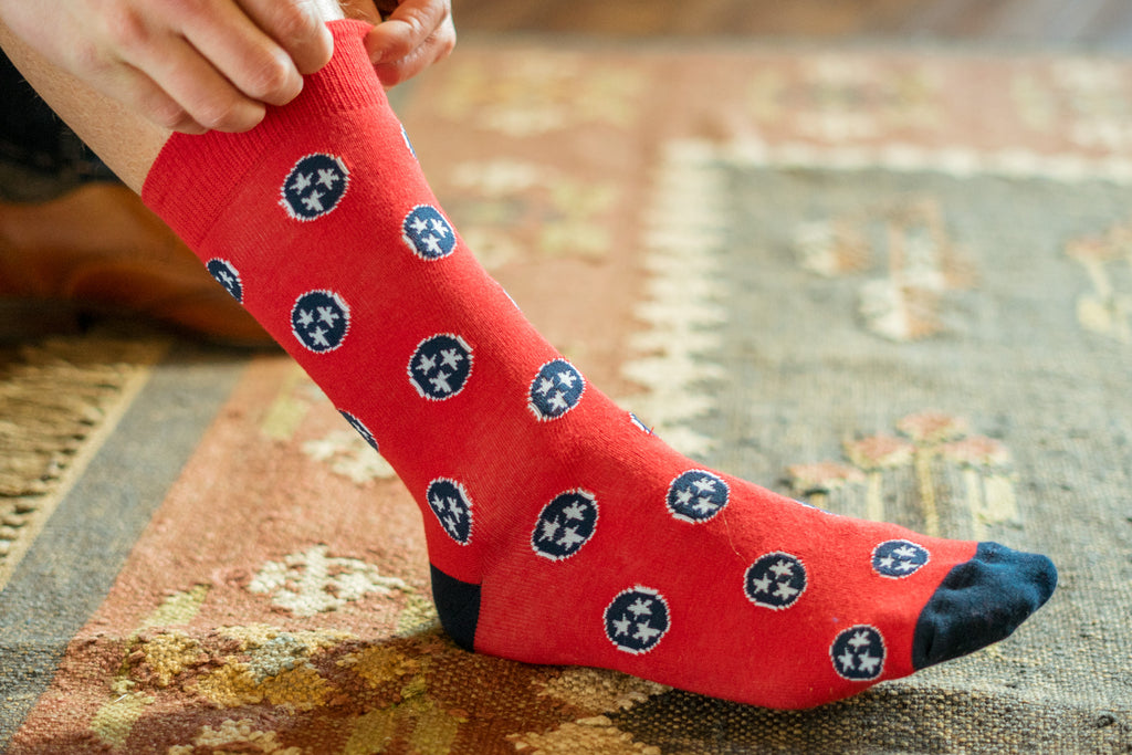 Volunteer Traditions Red with Navy Tristar sock on foot.