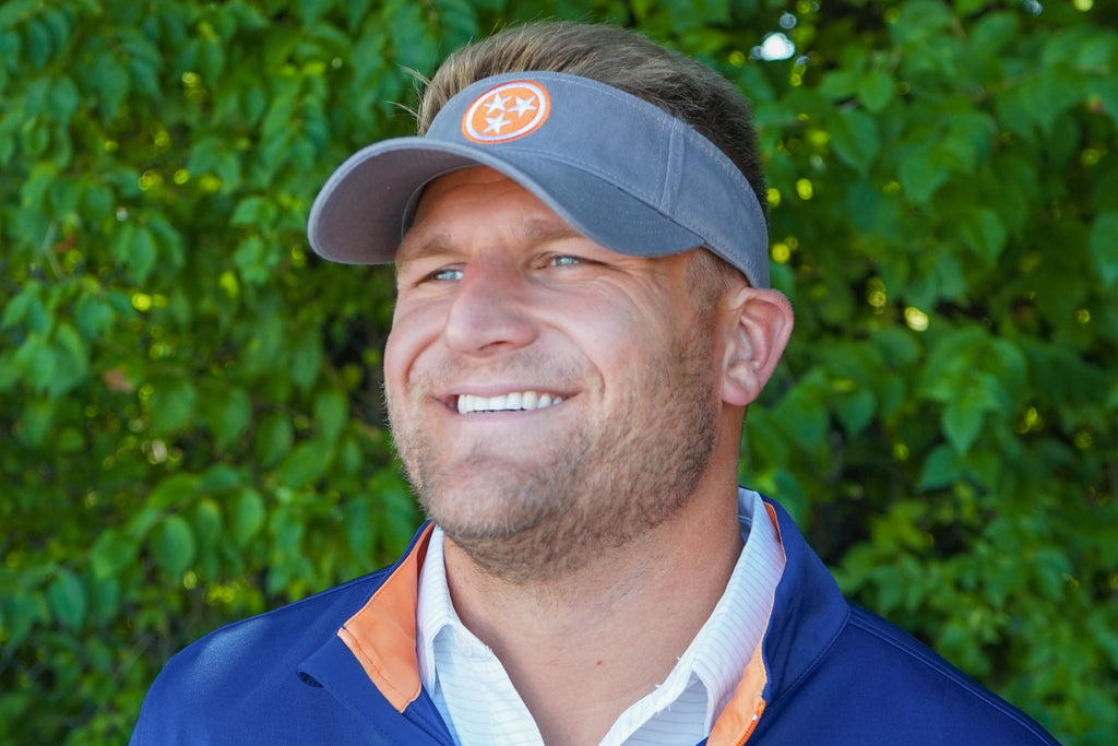 Volunteer Traditions Grey with Orange Tennessee Tristar Visor on head.