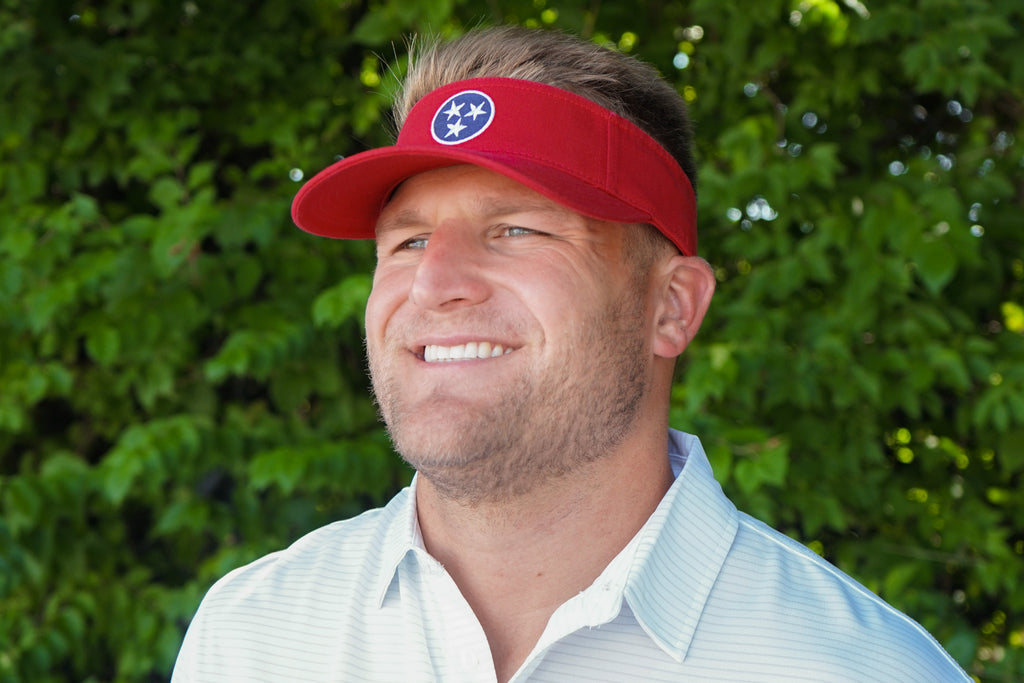 Volunteer Traditions Red with Navy Tennessee Tristar Visor on head.