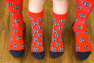 Volunteer Traditions Red and Navy Kid's Tristar Socks on Kids Feet next to Adult Feet for comparison.